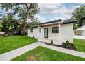 Inviting home exterior with a well-kept lawn and sidewalk at 6504 N 13Th St, Tampa, FL 33604