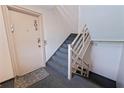 Condo stairway featuring gray carpeted steps, wooden railings, and unit door at 6700 Sunset Way # 303, St Pete Beach, FL 33706