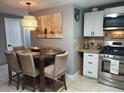 Eat-in kitchen dining area with modern stainless steel appliances, granite countertops and stylish light fixture at 8129 23Rd N Ave, St Petersburg, FL 33710