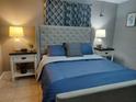 Comfortable main bedroom with large upholstered headboard, lamps and decorative pillows at 8129 23Rd N Ave, St Petersburg, FL 33710