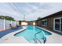 Inviting backyard pool with a white privacy fence and an adjacent patio area for outdoor enjoyment at 8305 75Th Pl, Seminole, FL 33777