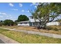 Charming two-story home with a well-manicured lawn and mature trees at 8413 Lopez Dr, Tampa, FL 33615