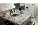 The modern kitchen boasts granite countertops, a stainless steel sink, and matching appliances at 8423 Edgewater Place Blvd, Tampa, FL 33615