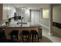Kitchen with white cabinets, granite counters, stainless appliances, breakfast bar and tile flooring at 8423 Edgewater Place Blvd, Tampa, FL 33615
