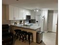 Bright kitchen features white cabinets, stainless appliances, granite countertops, and breakfast bar seating at 8423 Edgewater Place Blvd, Tampa, FL 33615