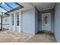 Covered front porch with textured gray walls and a decorative front door with glass detailing at 9107 Spring Hill Dr, Spring Hill, FL 34608