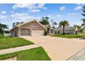 Well-maintained single-story home featuring a manicured lawn, arched windows, and a spacious two-car garage at 9219 Irondale Ln, Hudson, FL 34667