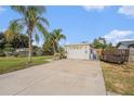 Exterior view of the single car garage and the driveway with lush landscaping around the house at 9616 56Th N St, Pinellas Park, FL 33782