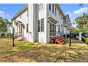 Back exterior of a two-story home with white siding, black railings, and a well-maintained grassy yard at 113 Bosphorous Ave # 5, Tampa, FL 33606