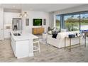 Open-concept living space with a kitchen island, comfortable seating, and scenic views of the lush backyard at 12305 49Th E St, Parrish, FL 34219