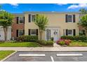 Charming townhome featuring a white door, manicured landscaping, and black shutters for added curb appeal at 13751 Juniper Blossom Dr, Tampa, FL 33618
