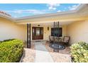 Inviting covered front porch with seating area, brick-paved walkway, and decorative foliage at 13821 Joyce Dr, Largo, FL 33774