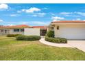 Eye-level view of the home's manicured front lawn and garden, accented with shrubbery and a paved walkway at 13821 Joyce Dr, Largo, FL 33774