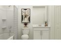 Cozy bathroom featuring a shower with tub, single sink vanity with white cabinets and neutral paint color at 15045 Zircon Red Dr, Wimauma, FL 33598