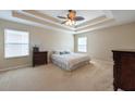 Bright bedroom with a tray ceiling, ceiling fan, and carpeted floors at 18424 Cypress Bay Pkwy, Land O Lakes, FL 34638