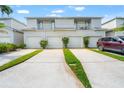 Charming townhome exterior with two stories, garages, and landscaped driveways at 1936 Heron Cove Dr # 104, Lutz, FL 33549