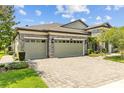 Spacious three-car garage with brick paved driveway and beautiful landscaping at 21642 Emory Oak Pl, Land O Lakes, FL 34637