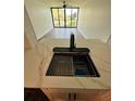 Bright kitchen featuring stone countertops, black sink, black faucet, and stainless-steel dish rack at 2424 W Tampa Bay Blvd # 203, Tampa, FL 33607