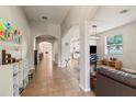 Inviting hallway with tile flooring, arched doorways, and views into the living room and kitchen at 2903 Cypress Bowl Rd, Lutz, FL 33558