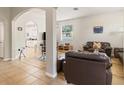 Spacious living room featuring tile and wood flooring, an archway, and comfortable seating at 2903 Cypress Bowl Rd, Lutz, FL 33558