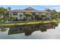 Waterfront condo building reflecting in a serene pond surrounded by lush greenery at 3366 Mermoor Dr # 1106, Palm Harbor, FL 34685