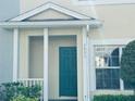 Inviting entrance featuring a teal front door and white support beams on the front porch at 3531 High Hampton Cir, Tampa, FL 33610