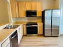 Bright kitchen featuring modern appliances, stainless steel refrigerator, and light wood cabinets at 3531 High Hampton Cir, Tampa, FL 33610