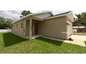 Charming single-story home featuring a modern exterior, well-maintained lawn, and an inviting covered entryway at 36777 Thomas Jefferson Rd, Dade City, FL 33525