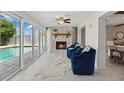 Bright living room featuring a stone fireplace, large sliding doors, and tile floors with views of the pool at 3912 Doral Dr, Tampa, FL 33634