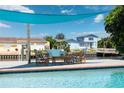 Inviting poolside outdoor lounge area with comfortable seating and waterfront views under a sunshade at 3912 Doral Dr, Tampa, FL 33634