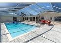 Enclosed pool with clear roof and paved deck with outdoor seating at 4055 Floramar Ter, New Port Richey, FL 34652