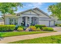 Charming one-story home with lush landscaping, manicured lawn, and a three car garage at 4093 Epic Cv, Land O Lakes, FL 34638