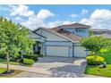 Two-story home with a three-car garage, well manicured lawn and stone accents at 4093 Epic Cv, Land O Lakes, FL 34638