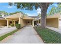 Townhouse featuring convenient covered parking and lush greenery, creating an inviting exterior at 413 Somerset Ln, Palm Harbor, FL 34684