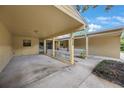 Welcoming townhouse facade, highlighting a covered driveway and charming landscaping at 413 Somerset Ln, Palm Harbor, FL 34684