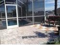 Private screened-in lanai with paver patio surrounds a sparkling pool with spa and waterfall features at 4512 River Overlook Dr, Valrico, FL 33596