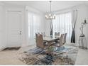 Contemporary dining room with modern chandelier, sleek table and seating, and natural light at 4914 Sienna Isles Ave, Wimauma, FL 33598