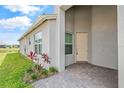 Well-maintained home featuring a brick-paved entryway, neutral paint, and view of the community lake at 4914 Sienna Isles Ave, Wimauma, FL 33598