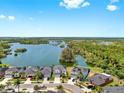 Stunning aerial view of homes nestled by a picturesque lake with lush greenery and blue skies, creating a serene setting at 5040 Inshore Landing Dr, Apollo Beach, FL 33572