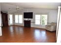 Open living room featuring wood flooring, built-in fireplace and entertainment center at 5714 Cheyenne St, Zephyrhills, FL 33542