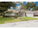 Charming single-story home featuring a tile roof, well-maintained lawn, and an attached two-car garage at 5812 Garden Lakes Majestic, Bradenton, FL 34203