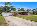Property featuring front lawn, driveway, and a white fence at 5905 Berkford Dr, Holiday, FL 34690