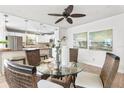 Inviting dining area with a glass table, wicker chairs, stylish ceiling fan, and views of kitchen at 6190 80Th N St # 102, St Petersburg, FL 33709