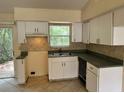 Bright kitchen with tile backsplash, white cabinets, and black appliances at 650 Palm Pl, Safety Harbor, FL 34695