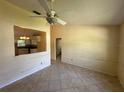 Spacious living room featuring tile floors, ceiling fan, and view into the kitchen at 650 Palm Pl, Safety Harbor, FL 34695