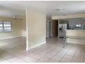 Bright living room featuring tile floors, a ceiling fan, and large windows that let in ample natural light at 8503 N Willow Ave, Tampa, FL 33604