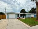 Charming single-story home featuring a well-manicured lawn, fresh landscaping, and a one-car garage at 9005 Rainbow Ln, Port Richey, FL 34668