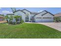 Stunning home featuring manicured lawn, mature palms, brick drive and a 3-car garage at 9208 Brindlewood Dr, Odessa, FL 33556