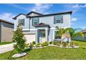 Charming home with a manicured lawn, garden bed with bright white rocks, and a covered front porch at 9734 Branching Ship Trce, Wesley Chapel, FL 33545