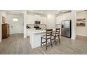 Bright kitchen features an island with seating, stainless steel appliances, and wood-look tile flooring at 10098 Banyan Breeze Blvd, Land O Lakes, FL 34638